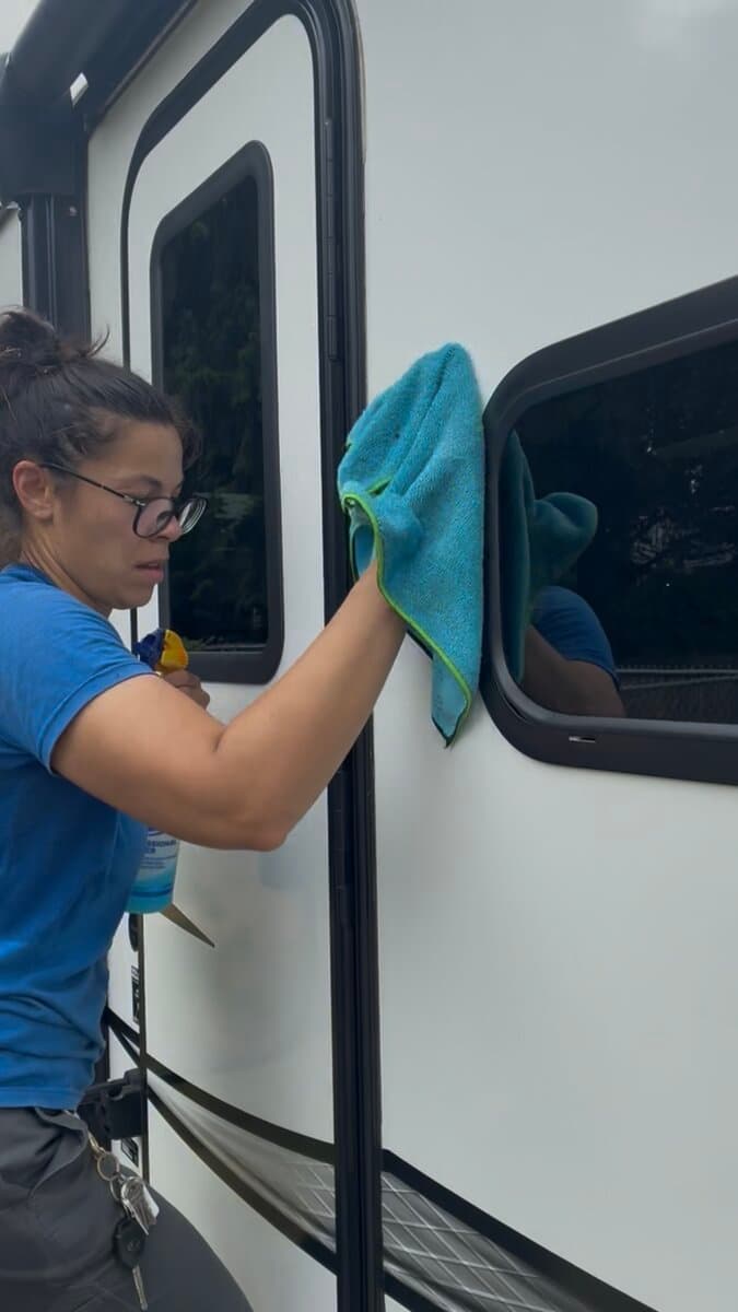 Wiping down RV windows with a microfiber cloth